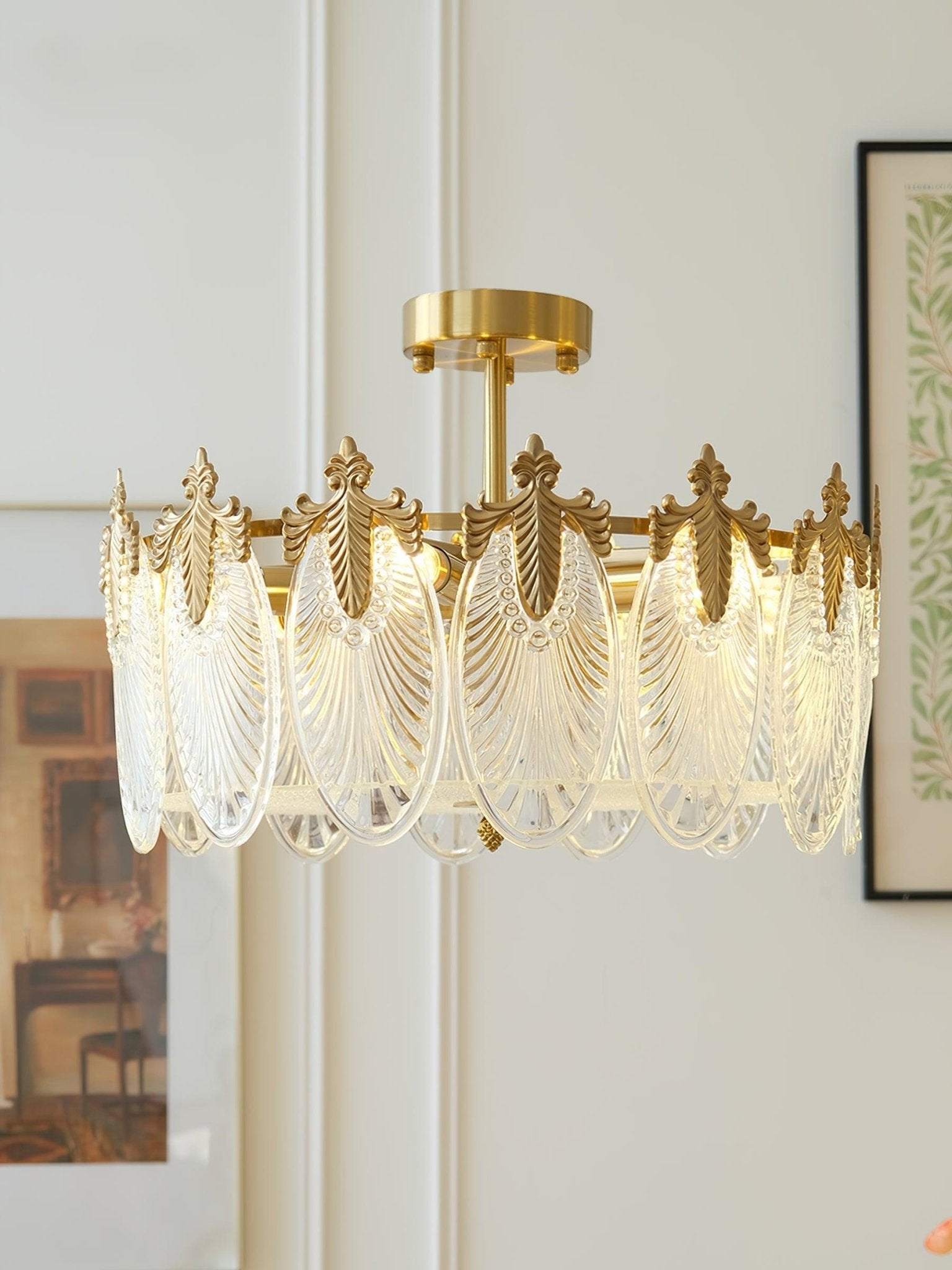 Glass petal chandelier hanging above a dining setting at night