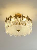 Glass petal chandelier lit warmly against a neutral ceiling