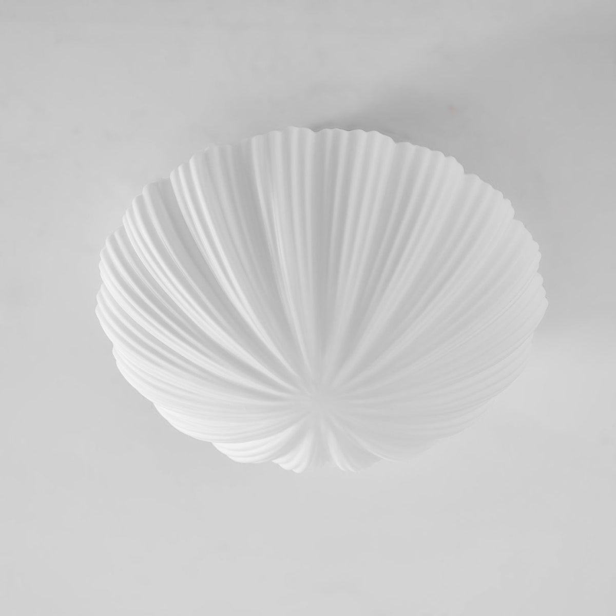 Another unlit angle shows the fine pleats on the shell-shaped shade of this Clérachic ceiling light.