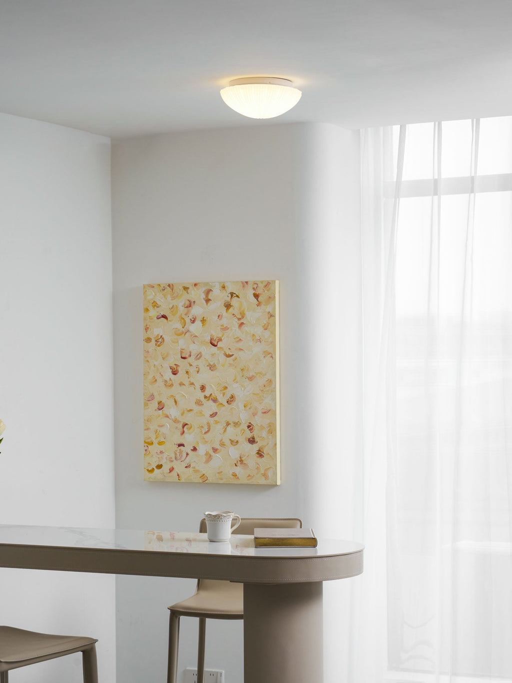 Glowing warm white in a room corner, this Clérachic ceiling light sits above sheer curtains and pale walls.