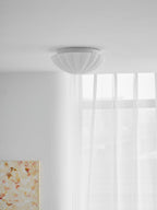 Seen from below, the ribbed underside of this Clérachic ceiling light is visible against a plain ceiling.
