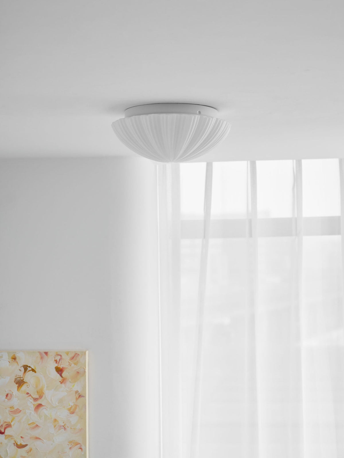 Seen from below, the ribbed underside of this Clérachic ceiling light is visible against a plain ceiling.