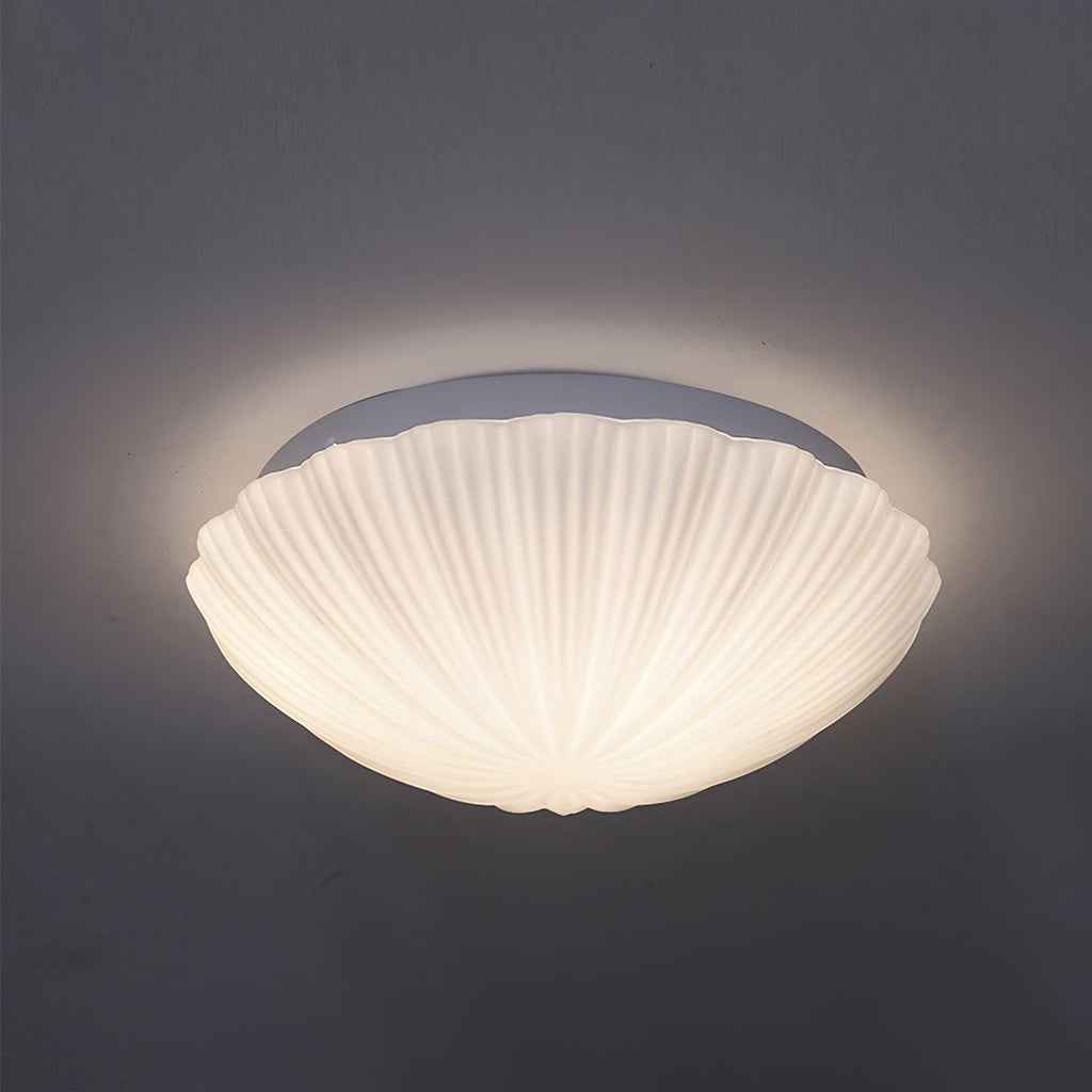 This Clérachic ceiling light glows warm white in side profile against a dark charcoal backdrop.