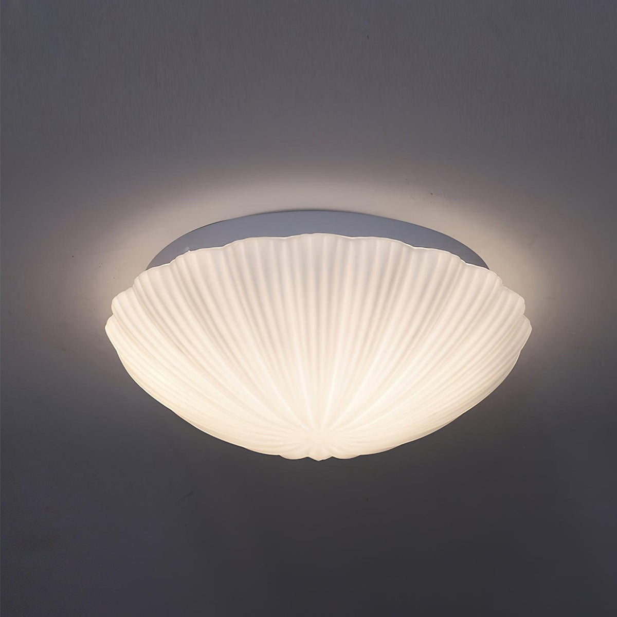 This Clérachic ceiling light glows warm white in side profile against a dark charcoal backdrop.
