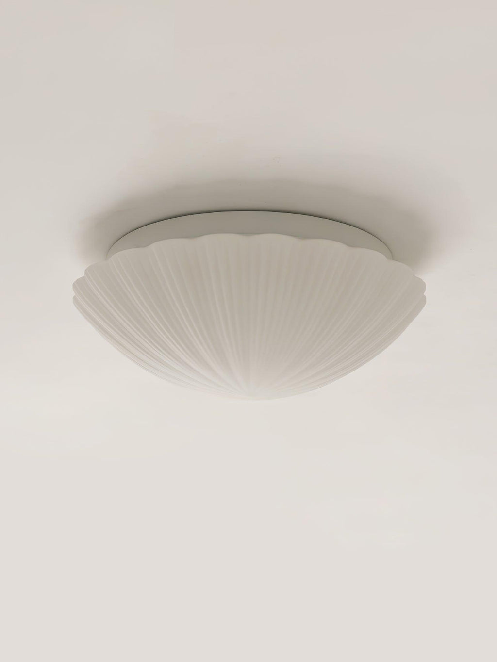 Shown from the side, this Clérachic ceiling light's white ribbed shade sits unlit on a plain white backdrop.