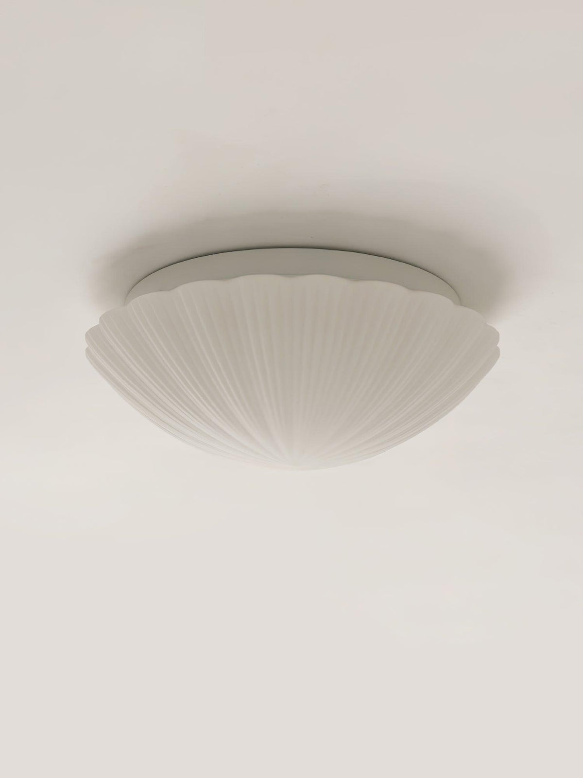 Shown from the side, this Clérachic ceiling light's white ribbed shade sits unlit on a plain white backdrop.