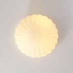Wall-mounted here rather than on a ceiling, this Clérachic light glows warm white, shown straight-on against a plain wall.