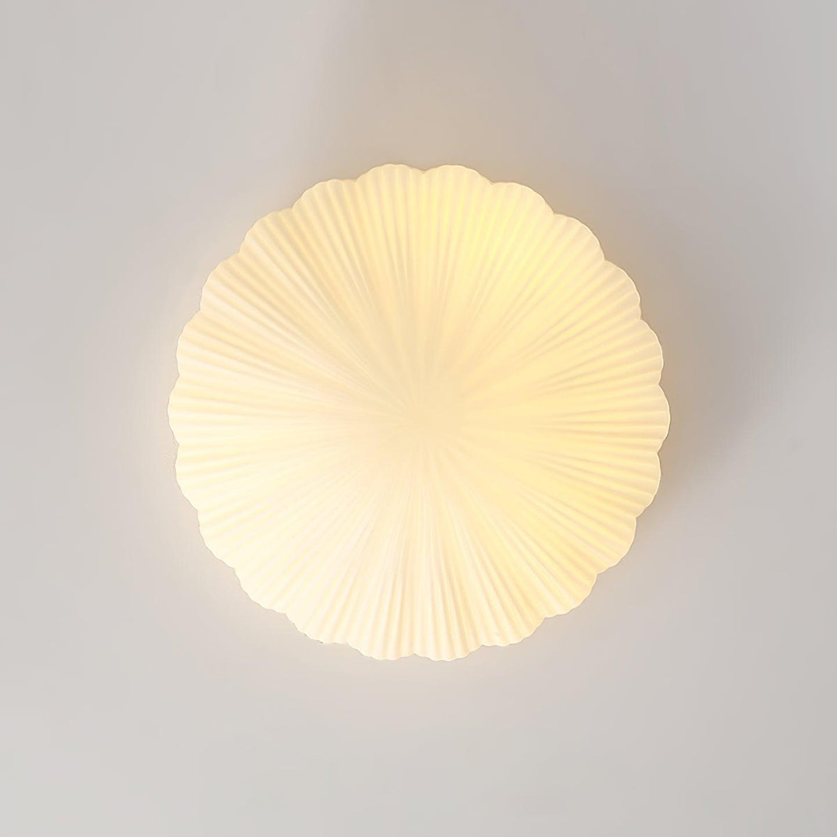 Wall-mounted here rather than on a ceiling, this Clérachic light glows warm white, shown straight-on against a plain wall.