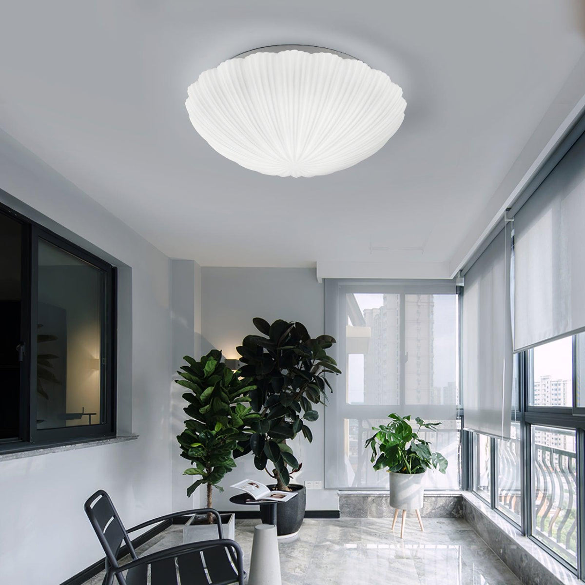 Above a sunlit room with potted plants and tall windows, this Clérachic flush-mount light sits unlit on the ceiling.