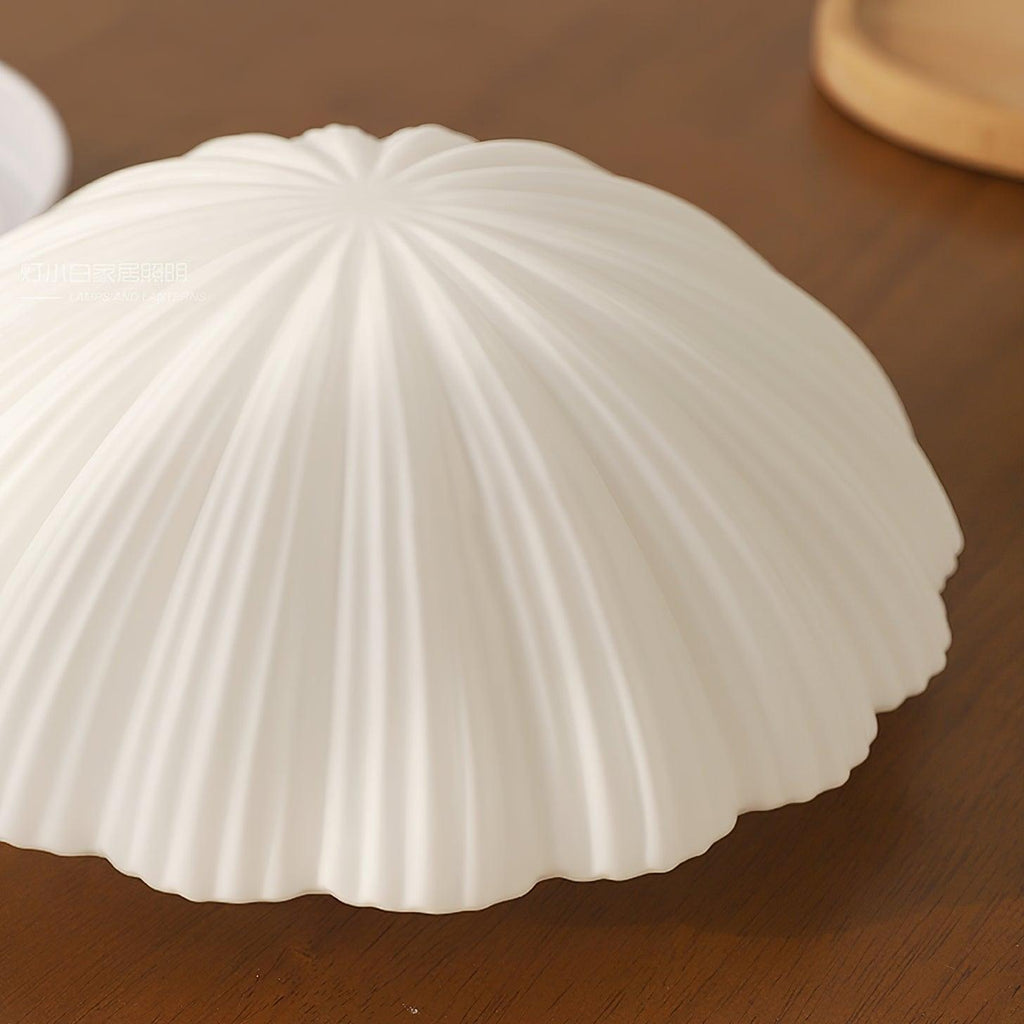Close view of the pleated ribs on this Clérachic ceiling light, shown unlit on a wood tabletop.