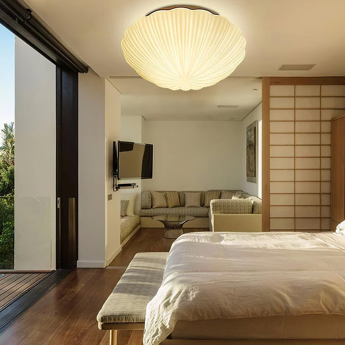 Glowing warm white, this Clérachic ceiling light lights an open bedroom and living area with sliding doors.