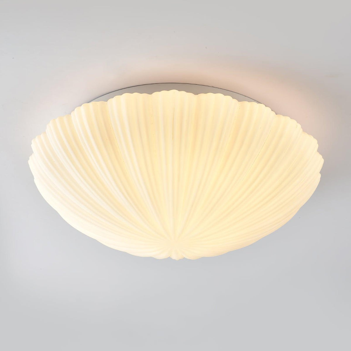 Lit from within, this Clérachic ceiling light shows its ribbed glass glowing cream against a grey backdrop.