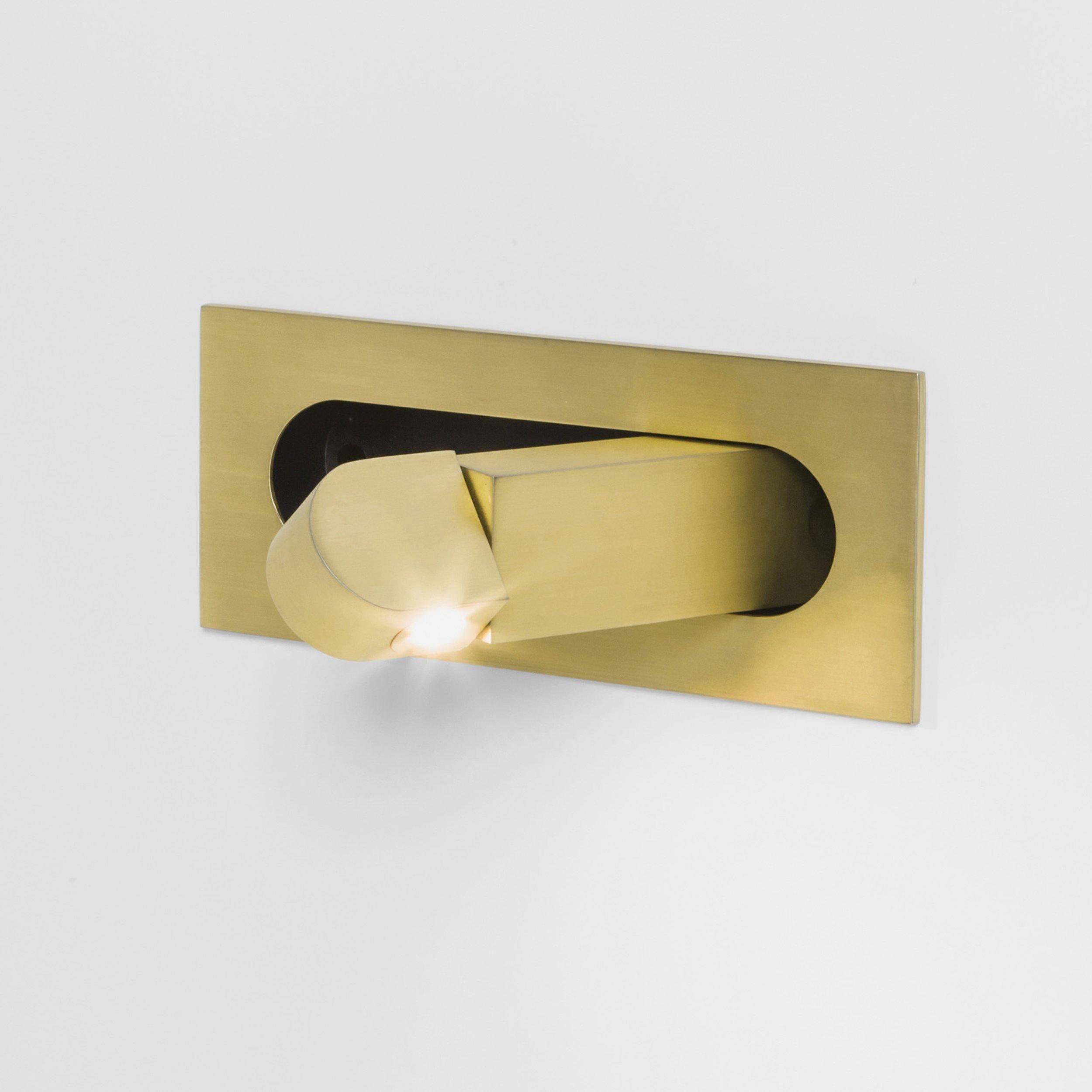 Modern LED bedside reading light in gold finish on a bedroom wall
