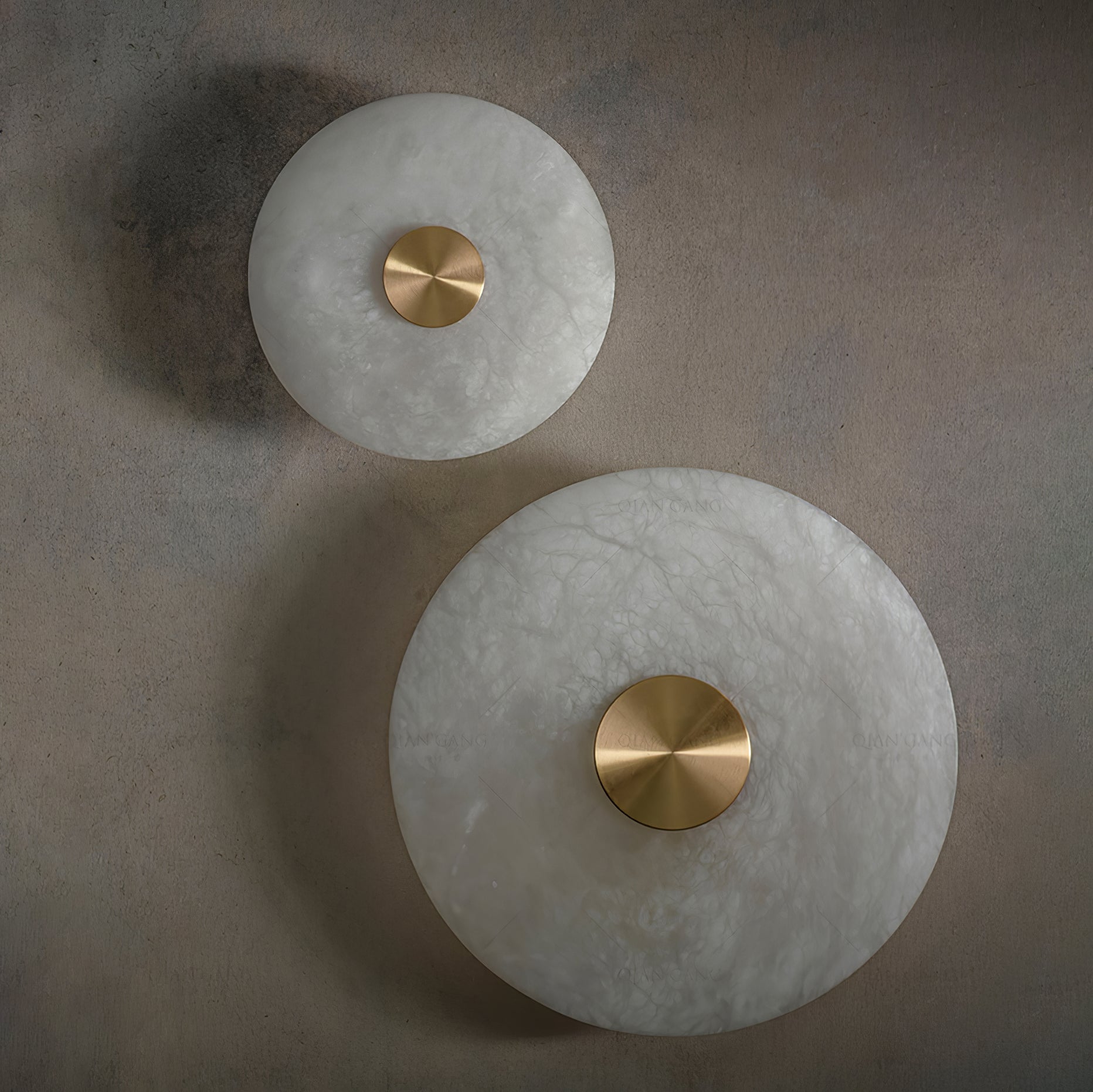 Two alabaster disc wall lights switched off, showing the raw stone grain and polished brass caps.