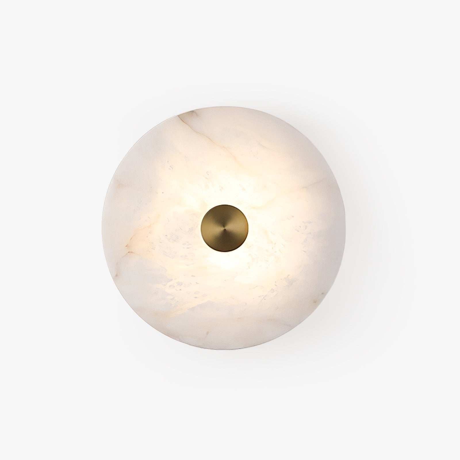 Studio shot of the lit alabaster disc sconce, brass cap centred on the marbled stone face.