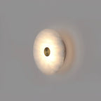 Angled view of the alabaster disc wall light, showing how shallow it sits against the wall.