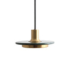 A green-veined stone disc pendant with a gold rim, angled close against white to show the Clérachic fixture's brass cap and cord.