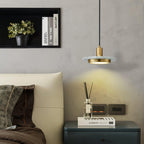 A Clérachic pendant light glows warm beside a cream armchair, lighting a reed diffuser on the side table.