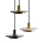 Three Clérachic pendant lights shown together in green marble, black marble and white marble finishes.