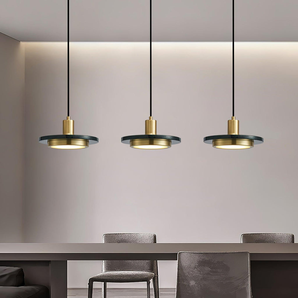Three black Clérachic pendant lights hang from a plain wall above a table in a soft grey dining room.