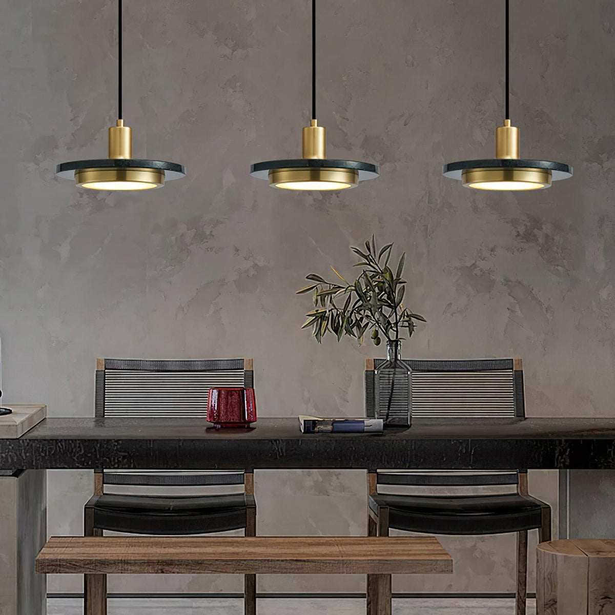 Three Clérachic pendant lights hang evenly spaced above a dark wood dining table set with a glass vase.