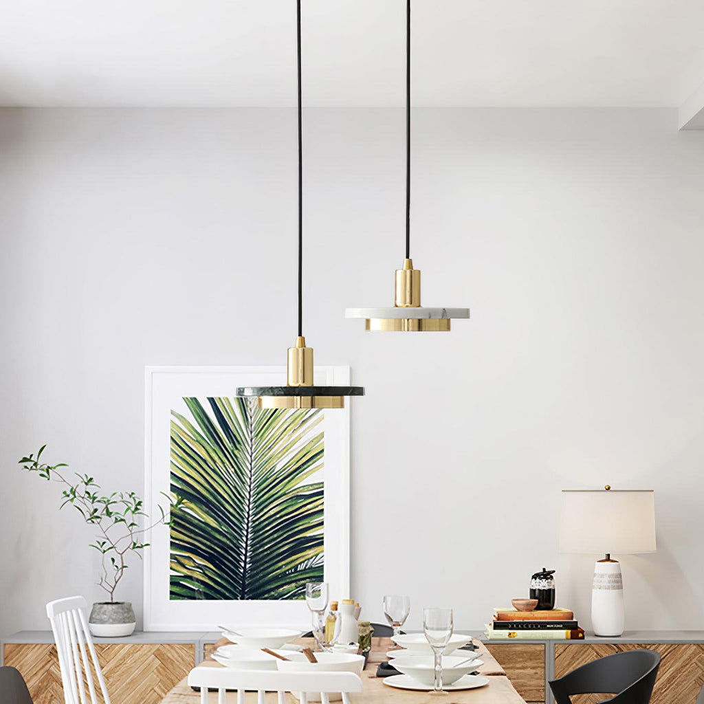Two Clérachic pendant lights hang near a framed botanical print in a dining area set with plates.
