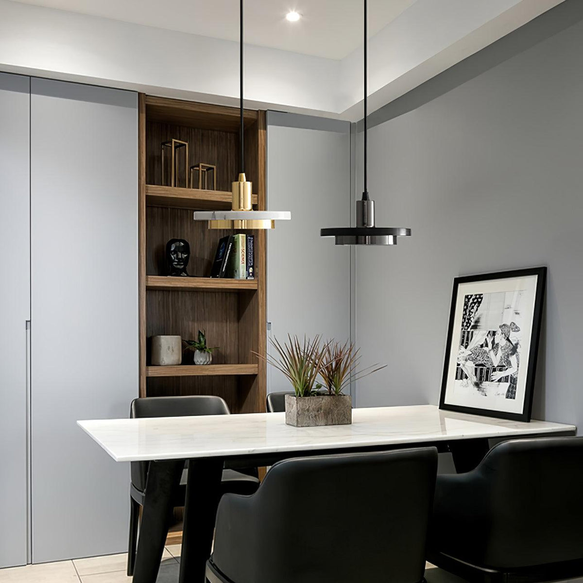 Two Clérachic pendant lights, one white marble and one black, hang above a marble table with black chairs.