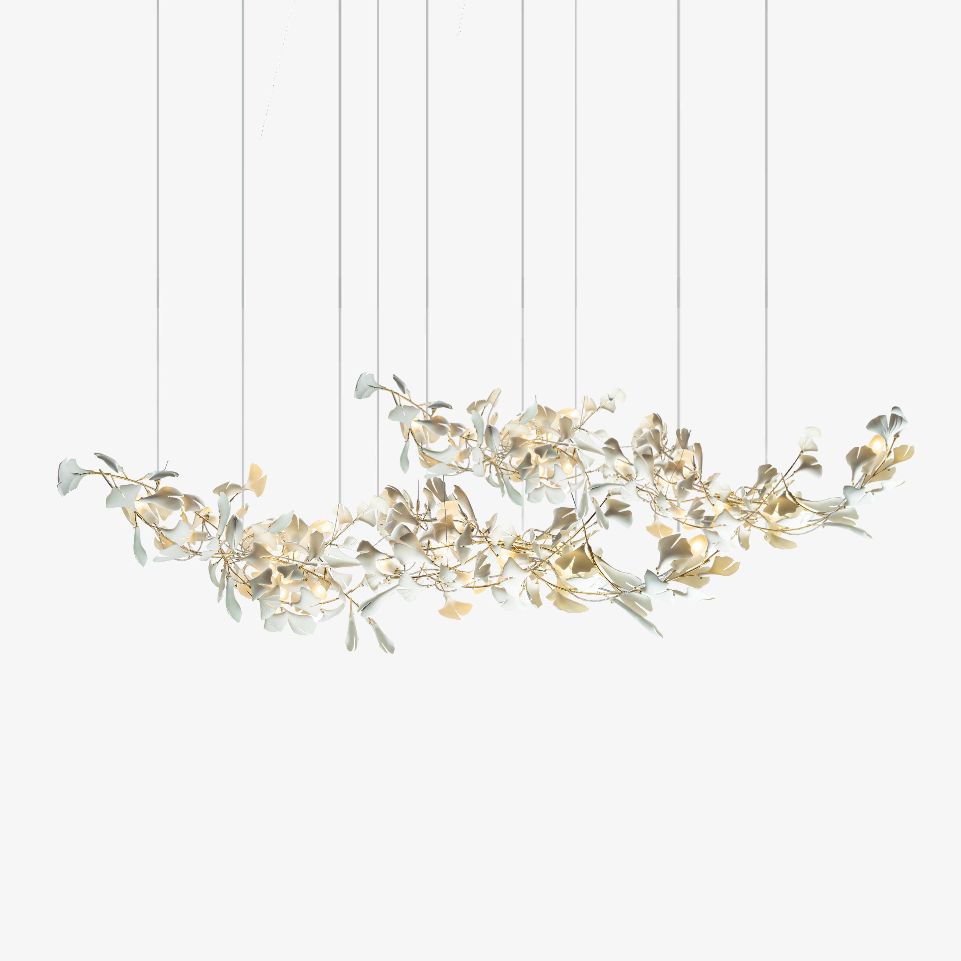 The double-layer gingko chandelier on white, gold branches and ceramic leaves spread along a wide horizontal drop.