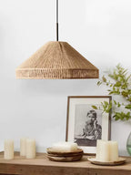 This Clérachic pendant hangs over a console with stacked plates, a vintage portrait and a vase of greenery.