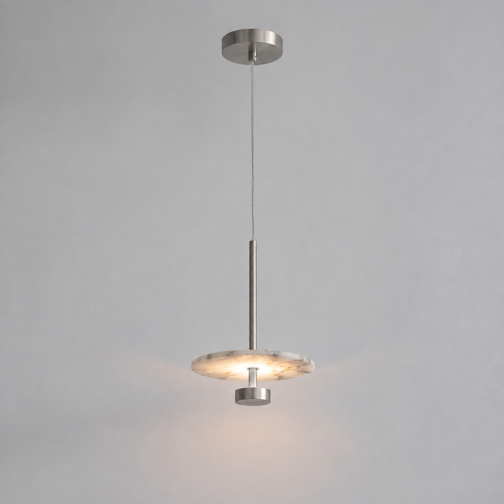 In brushed nickel, this Clérachic pendant hangs its flat alabaster disc from a slim rod against grey.