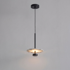 Shown lit against grey, this black Clérachic pendant drops its glowing alabaster disc from a slender rod.