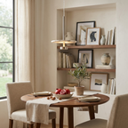 Lit over a round table in a bookshelf-lined nook, this nickel Clérachic pendant glows warmly.