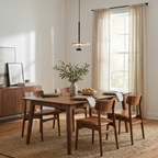 Above a walnut dining table with rust-leather chairs, this black Clérachic pendant lights the room.