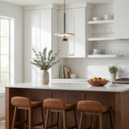 Beside open shelving, this black Clérachic pendant lights a white kitchen island from a slim black rod.