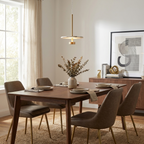 Above a dining table set with taupe chairs, this brass Clérachic pendant lights a console styled with art.
