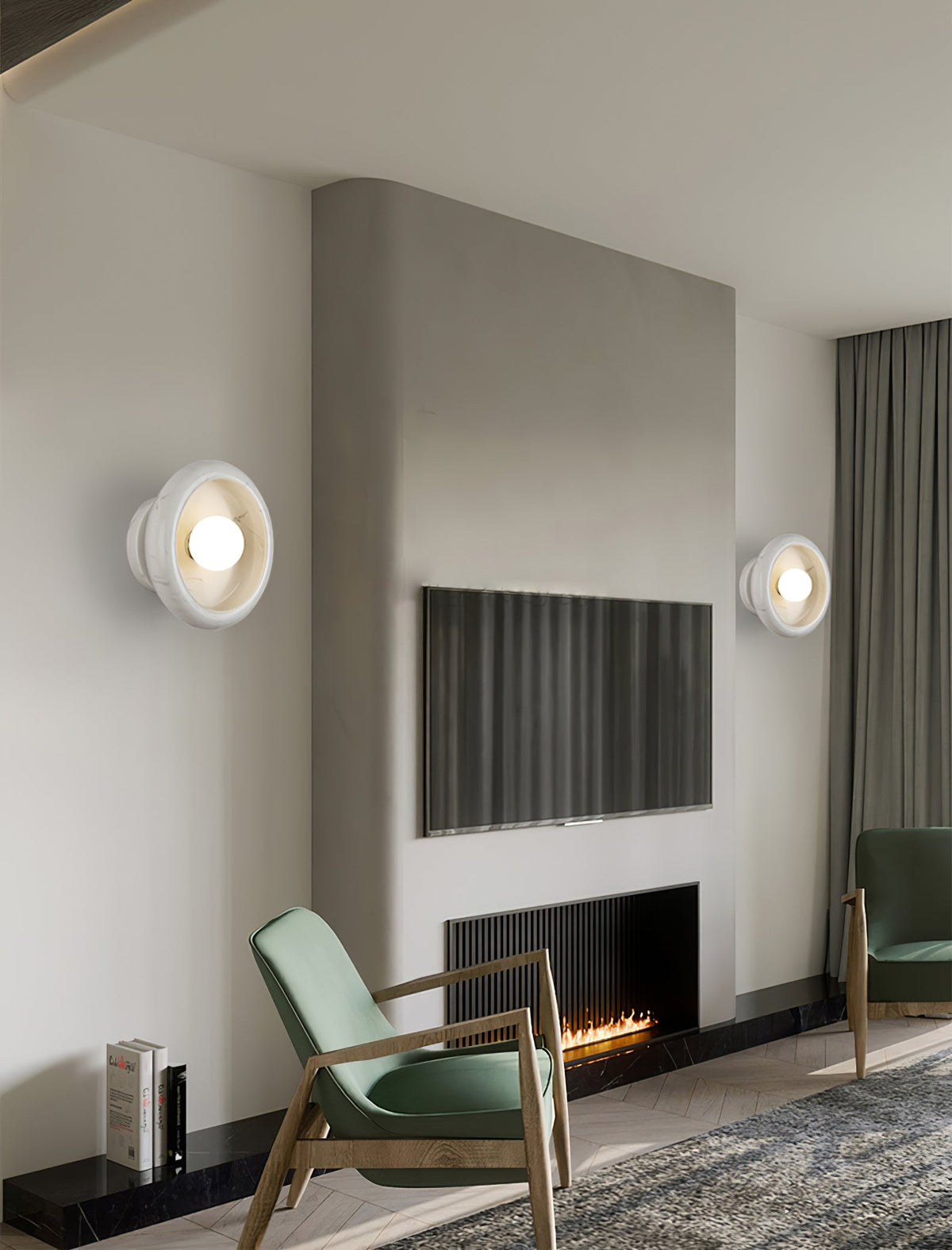 Two Clérachic white wall sconces lit in a living room with a fireplace, an armchair and a wall-mounted television.
