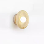 Clérachic beige jade wall sconce photographed at an angle on white, its warm marbled tones catching the light.