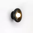Clérachic black marble wall sconce with an amber-tinted glass shade, photographed at an angle on white.