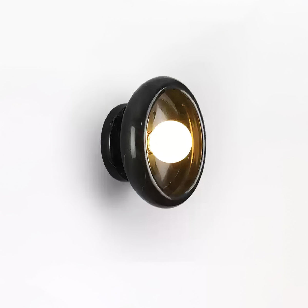 Clérachic black marble wall sconce with an amber-tinted glass shade, photographed at an angle on white.