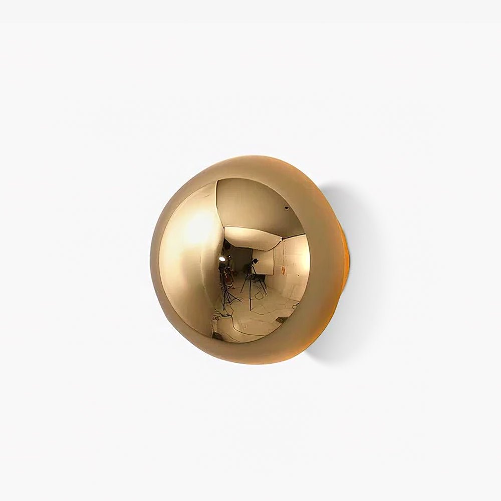 Polished sphere wall sconce mounted on a pale wall