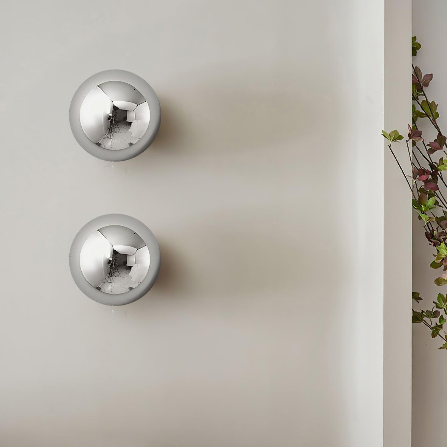 Polished sphere wall sconce with warm reflected glow