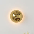 Polished sphere wall sconce shown straight on lit