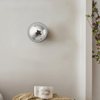 Polished sphere wall sconce in black with warm glow