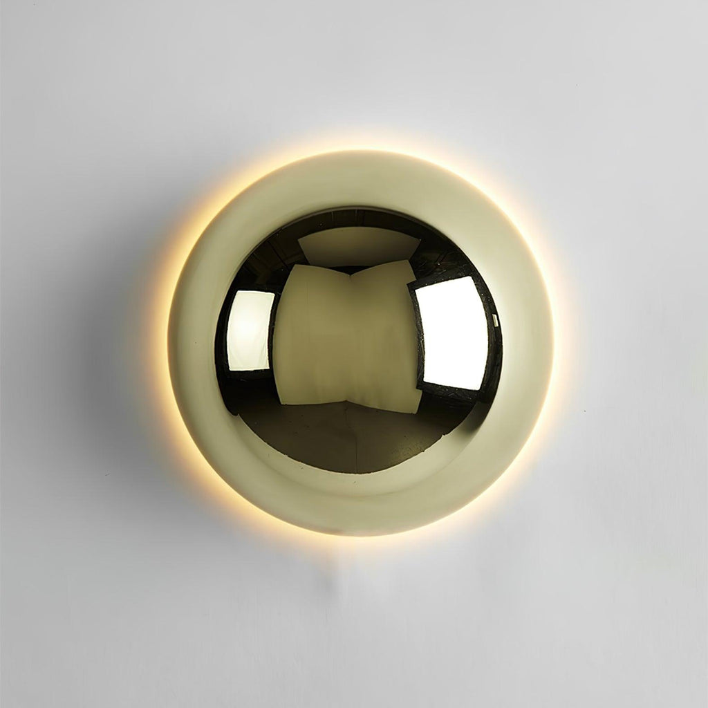 Polished sphere wall sconce glowing in an interior