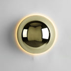 Polished sphere wall sconce glowing in an interior