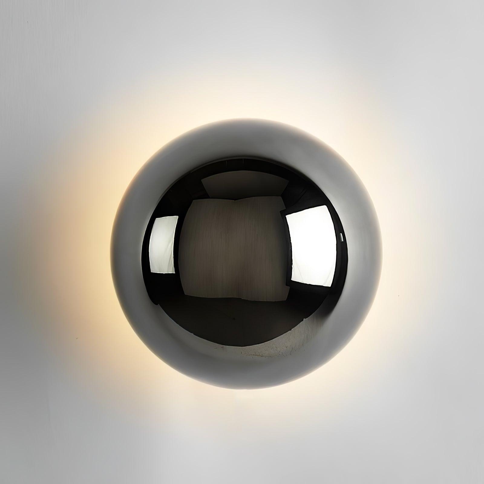Polished sphere wall sconce in chrome on a wall