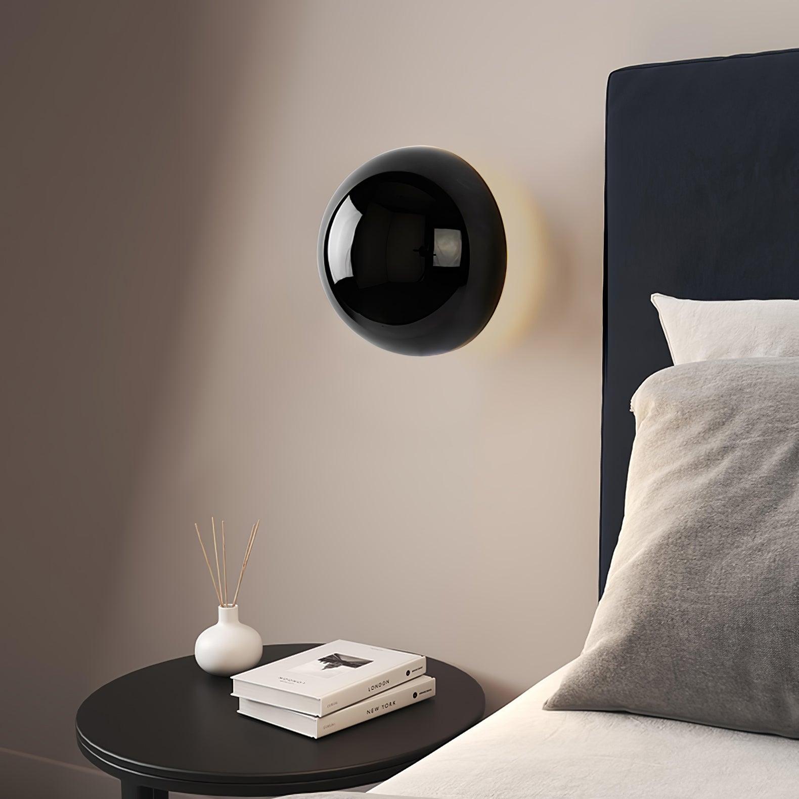 Polished sphere wall sconce shown at an angle