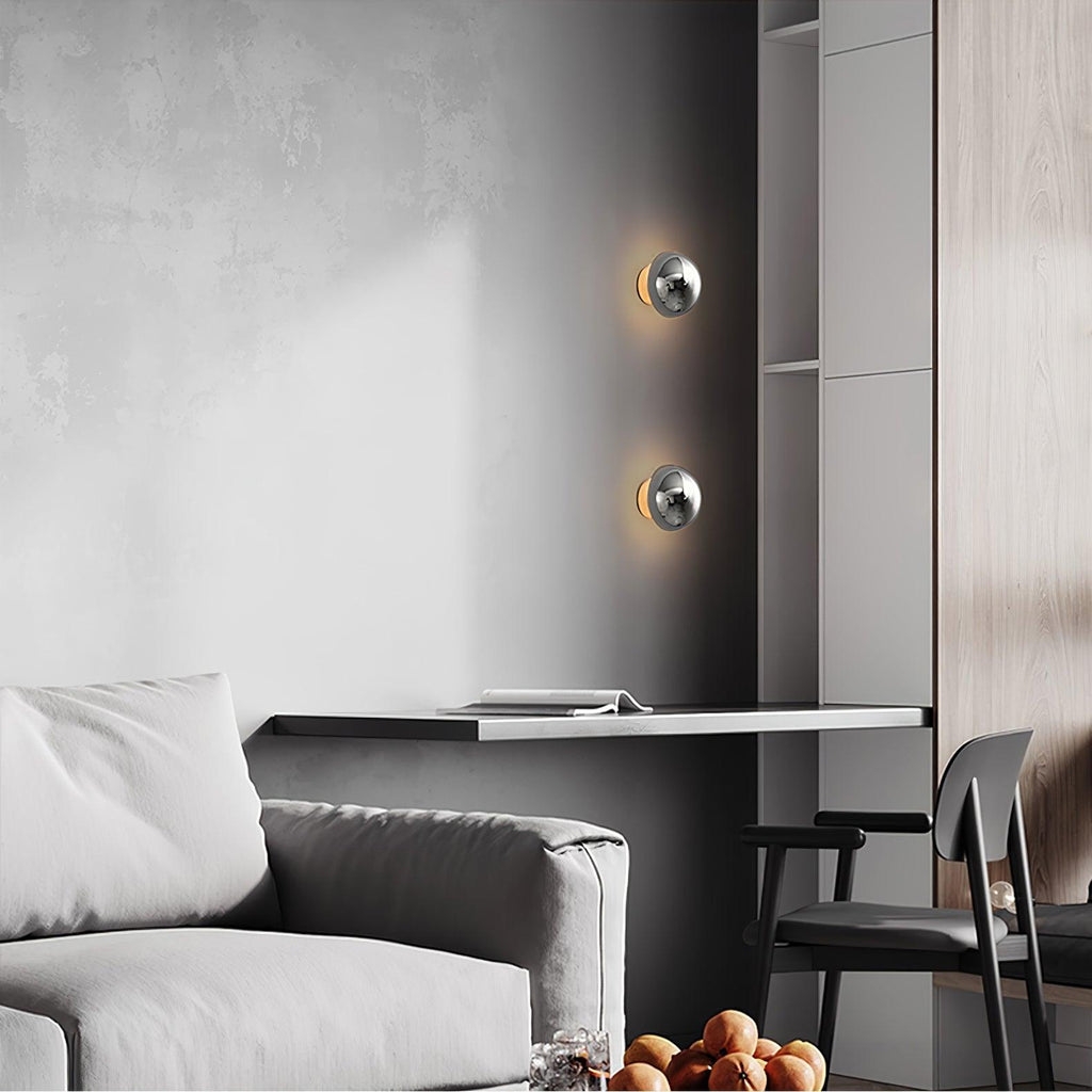 Polished sphere wall sconce with glossy reflective metal