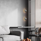Polished sphere wall sconce with glossy reflective metal