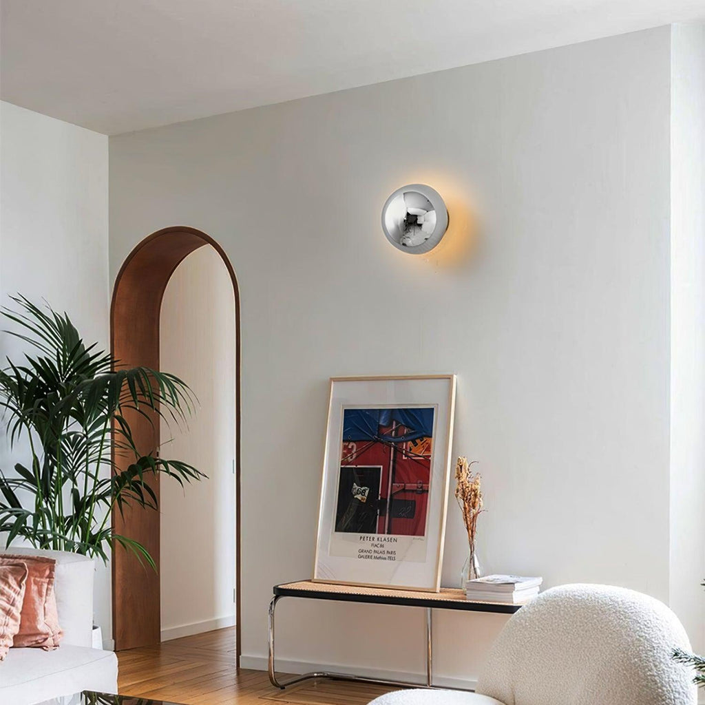 Polished sphere wall sconce with soft warm glow